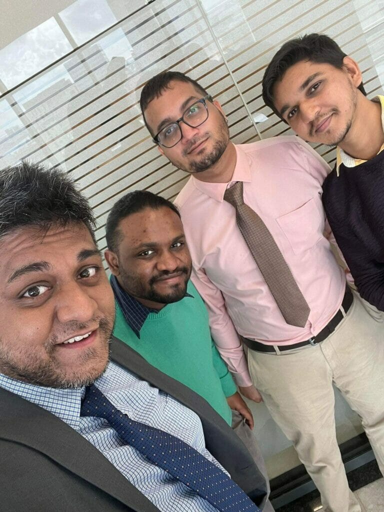 | GLAAD Four Mauritian people take a selfie in professional clothing with smiles on their faces.