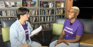Las Vegas training 2023 | GLAAD Lana, white, blue denim over purple shirt that reads: "I support LGBTQ youth" sitting adjacent to Zakkiyyah Niamah Salaam, black, bleach blonde hair, with purple shirt "I Support LGBTQ Youth" on it, with blue denim pants