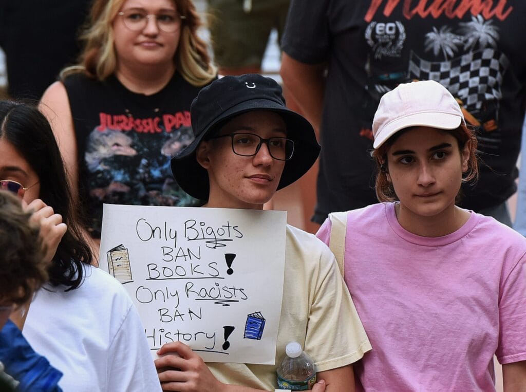 A person holds a placard at a rally to protest Florida education policies outside Orlando City Hall on April 21, 2023.