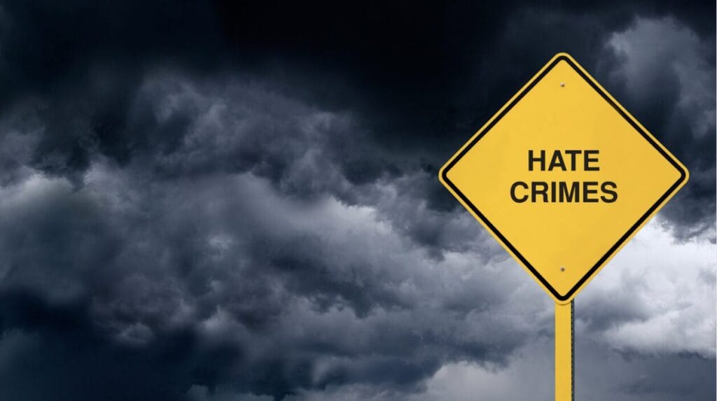 Stormy weather, yellow sign that says hate crimes