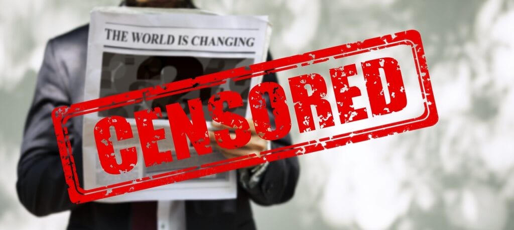 Black and white photo of someone reading a newspaper, you can't see their face, just their hands gropping the paper and the front page which reads: "The World is Changing" over the page is a read rectangle with red block letters in the center that read "CENSORED"