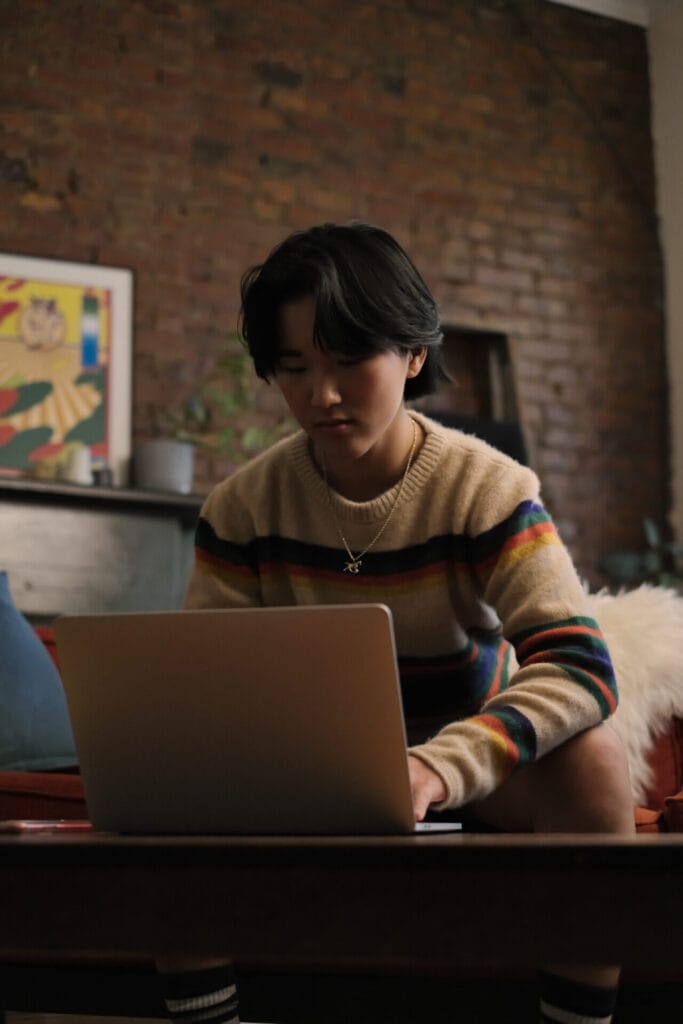 A non-binary person looking at a laptop | GLAAD A non-binary person looking at a laptop