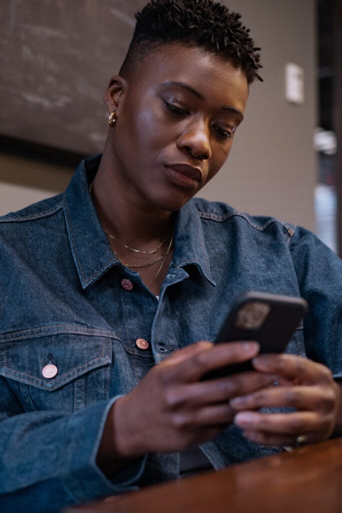 A non-binary person looking at a cellphone | GLAAD A non-binary person looking at a cellphone