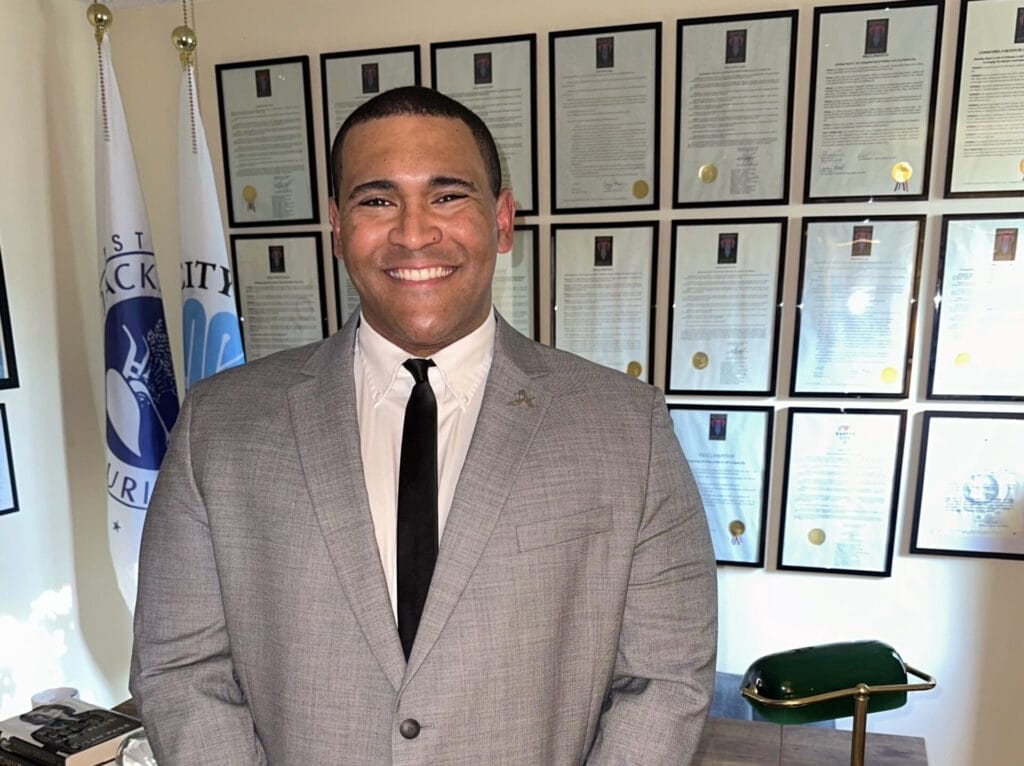 Justice Horn, black skin, dark short hair, grey suit with a black tie and white shirt standing in Kansas City government building