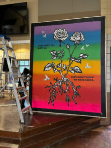 processed-B0A7C37A-060D-4FC4-9939-9C1AC1D1AC69 | GLAAD The mural soon after it was dropped off at Youth Service Center. "They tried to bury us, they didn't know we were seeds" reads the painting, a vertical, and massive painting in a rainbow gradient and a thick black paintings of flowers with their leaves and roots bare