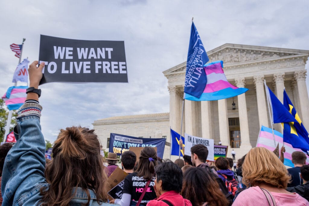 WASHINGTON DC, UNITED STATES - 2019/10/08: Participant holding a sign outsithe the Supreme Court. 133 protesters were arrested blocking the street across the Supreme Court in an act of non violent civil disobedience, as hundreds of LGBTQ+ advocates convened in Washington, DC for a national day of action as a community response to the landmark Supreme Court hearings that could legalize workplace discrimination, primarily against LGBTQ+ people, on the basis of sexual orientation, gender identity, and gender presentation.