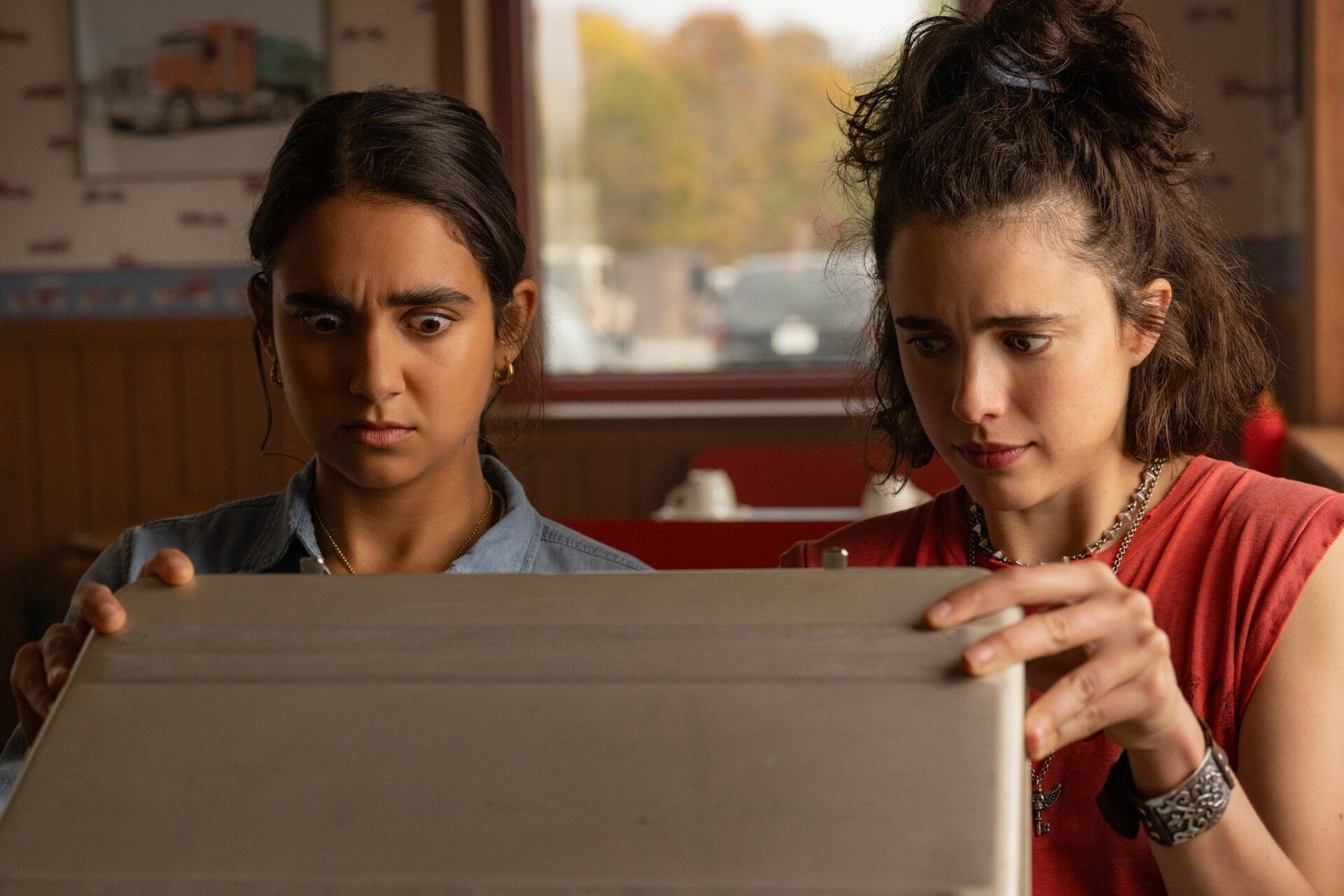 Geraldine Viswanathan and Margaret Qualley as Marian and Jamie in Drive-Away Dolls | GLAAD Geraldine Viswanathan and Margaret Qualley as Marian and Jamie in Drive-Away Dolls