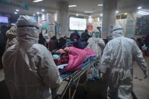 GettyImages-1196292480 | GLAAD TOPSHOT - In this photo taken on January 25, 2020, medical staff wearing protective clothing to protect against a previously unknown coronavirus arrive with a patient at the Wuhan Red Cross Hospital in Wuhan. - The number of confirmed deaths from a viral outbreak in China has risen to 54, with authorities in hard-hit Hubei province on January 26 reporting 13 more fatalities and 323 new cases. (Photo by Hector RETAMAL / AFP) (Photo by HECTOR RETAMAL/AFP via Getty Images)