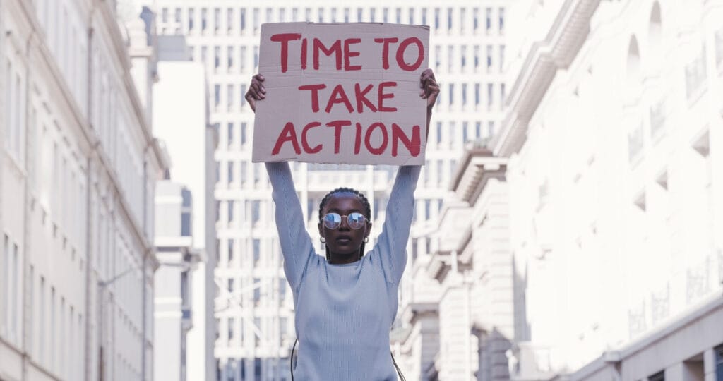 Protester holding cardboard sign Time to Take Action