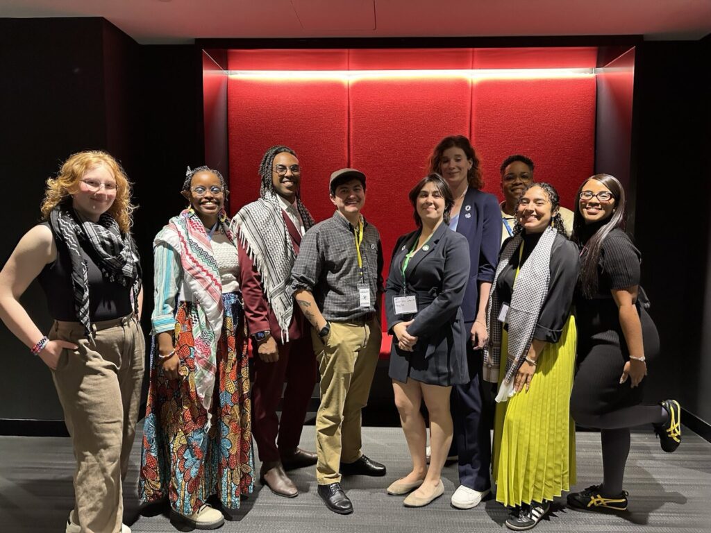 Nine members of Garden State Equality's staff pose in a red room for an event called Equality at Work