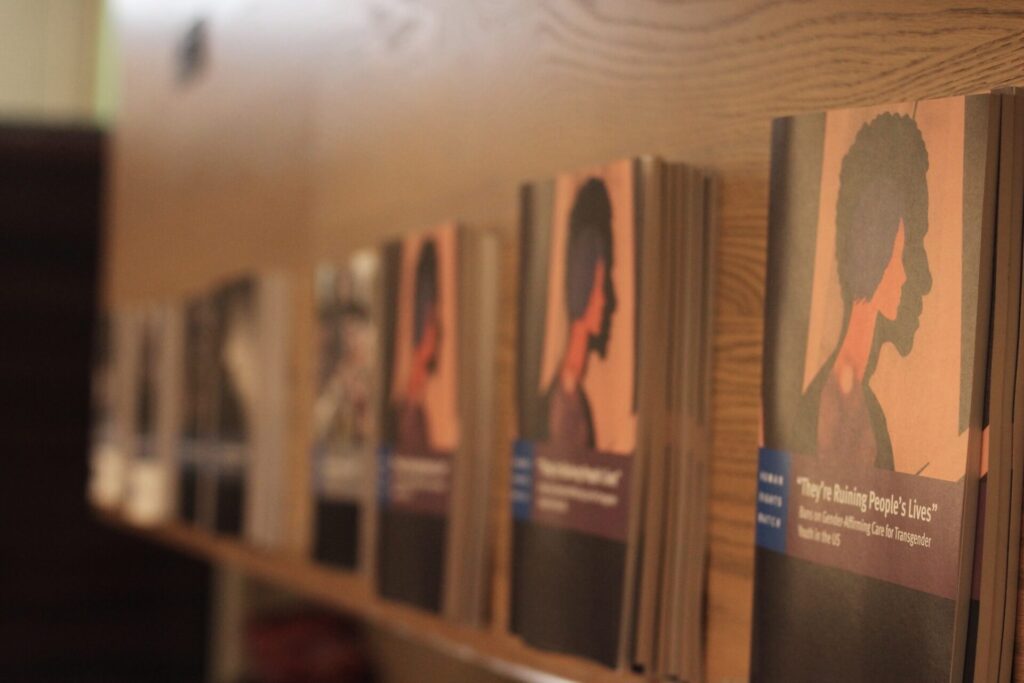 Photos of the physical "They're Ruining Our Lives Report" lined up on a table among other research. The other reports fade into a blur | GLAAD Photos of the physical "They're Ruining Our Lives Report" lined up on a table among other research. The other reports fade into a blur