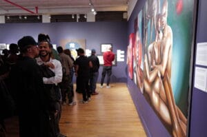 Visitors view artworks in a museum/gallery with a purple wall; a large colorful painting dominates the right side of the scene.